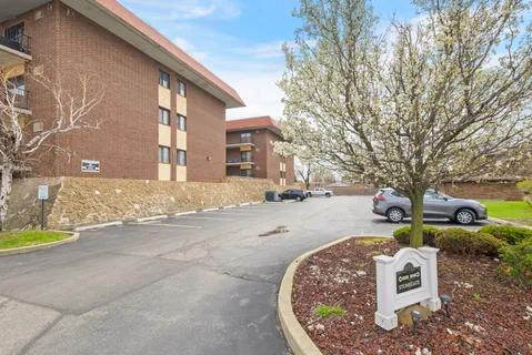 a front view of a house with a yard and trees