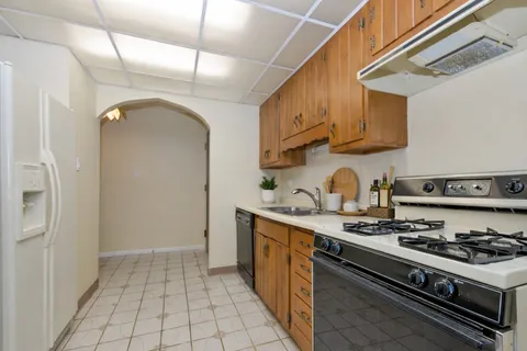a kitchen with stainless steel appliances granite countertop a sink stove and cabinets