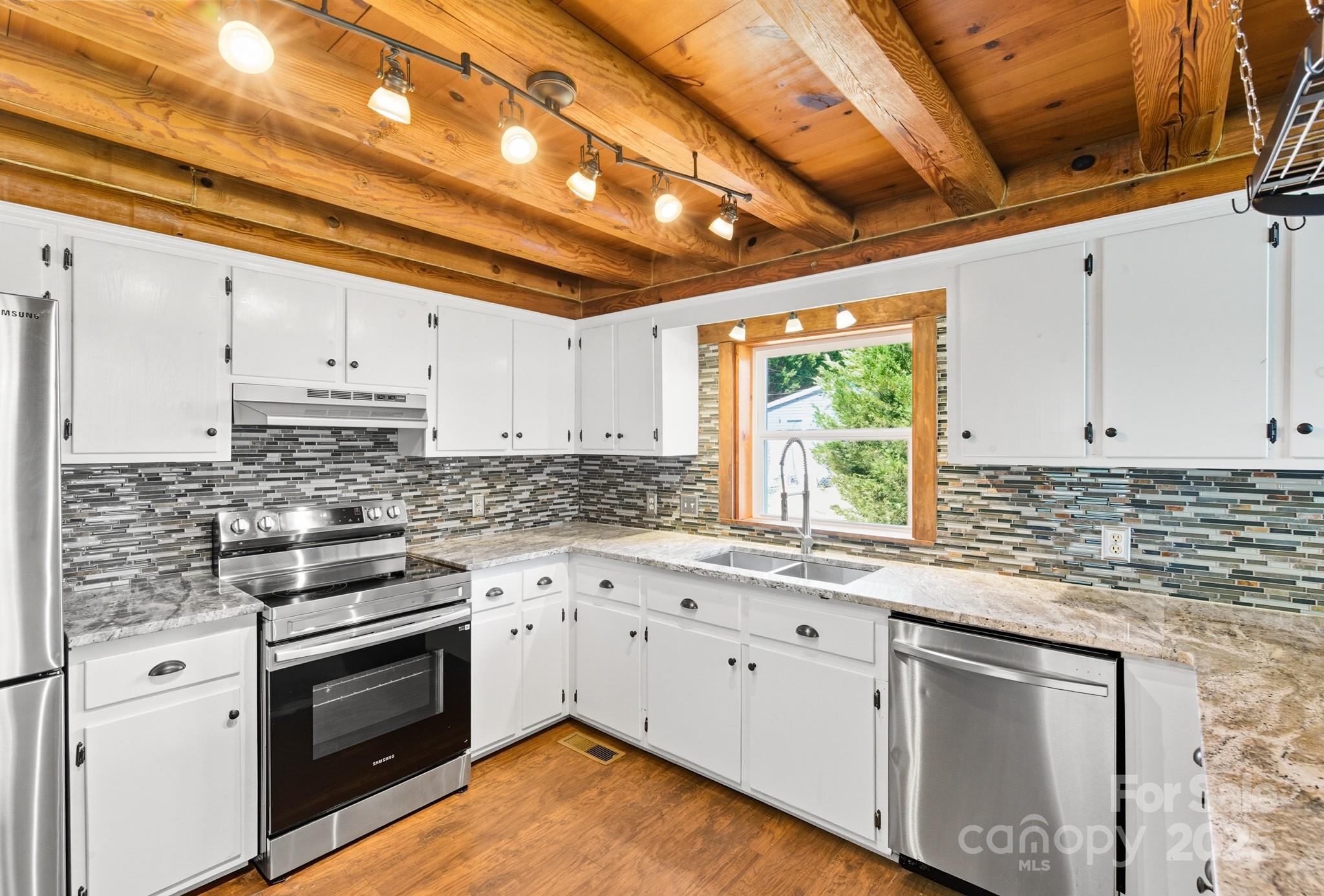 119 Yates Street Dallas, NC 28034 - Photo 13 of 47 a kitchen with stainless steel appliances granite countertop a stove a sink and white cabinets