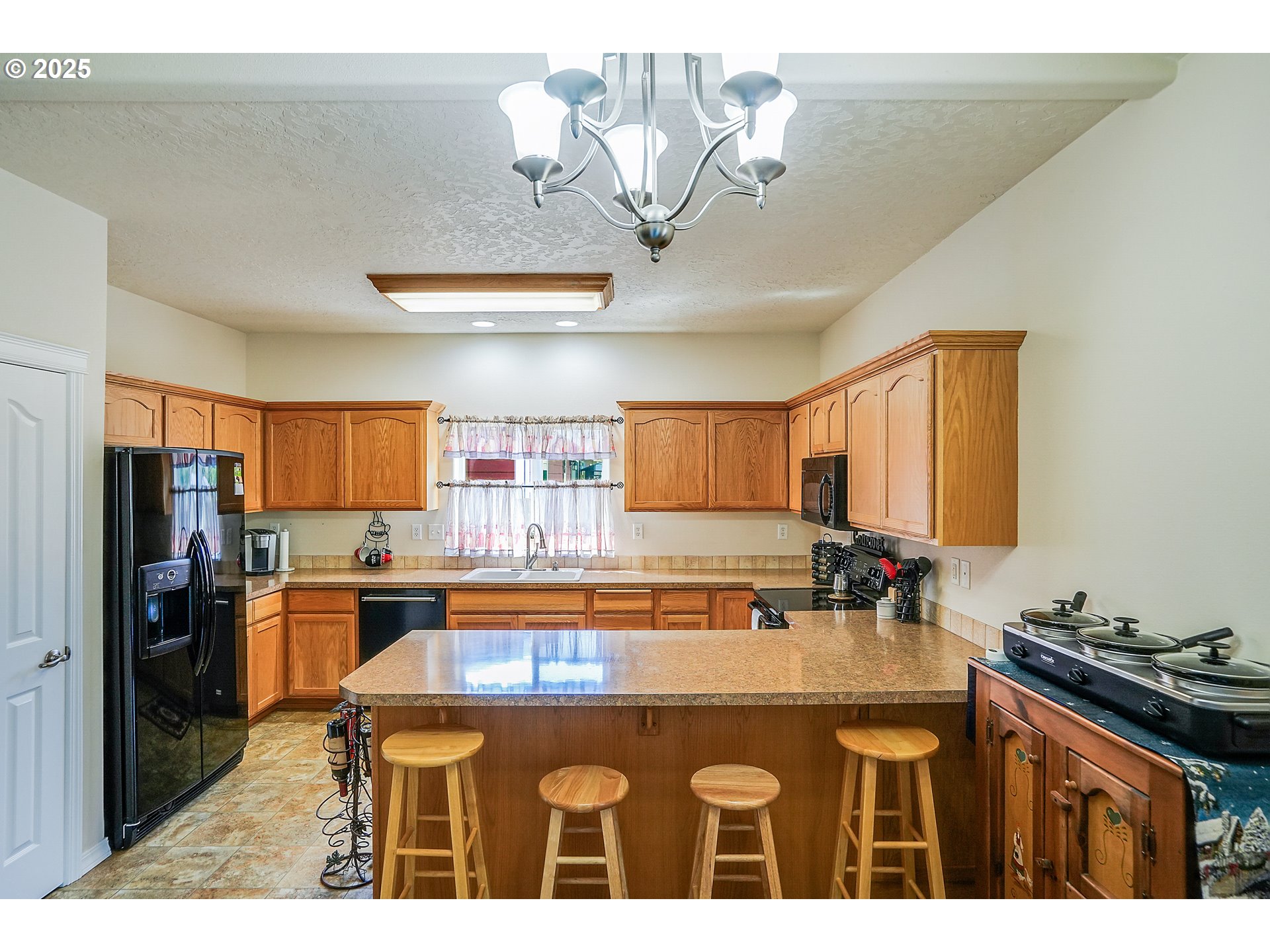 1231 Southwest 3rd Avenue Mill City, OR 97360 - Photo 12 of 48 a kitchen with stainless steel appliances granite countertop a sink a stove and a refrigerator