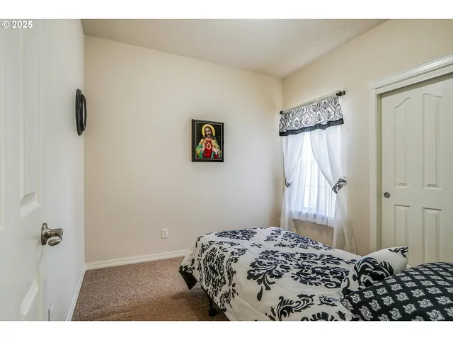 a bedroom with a bed and a painting on the wall