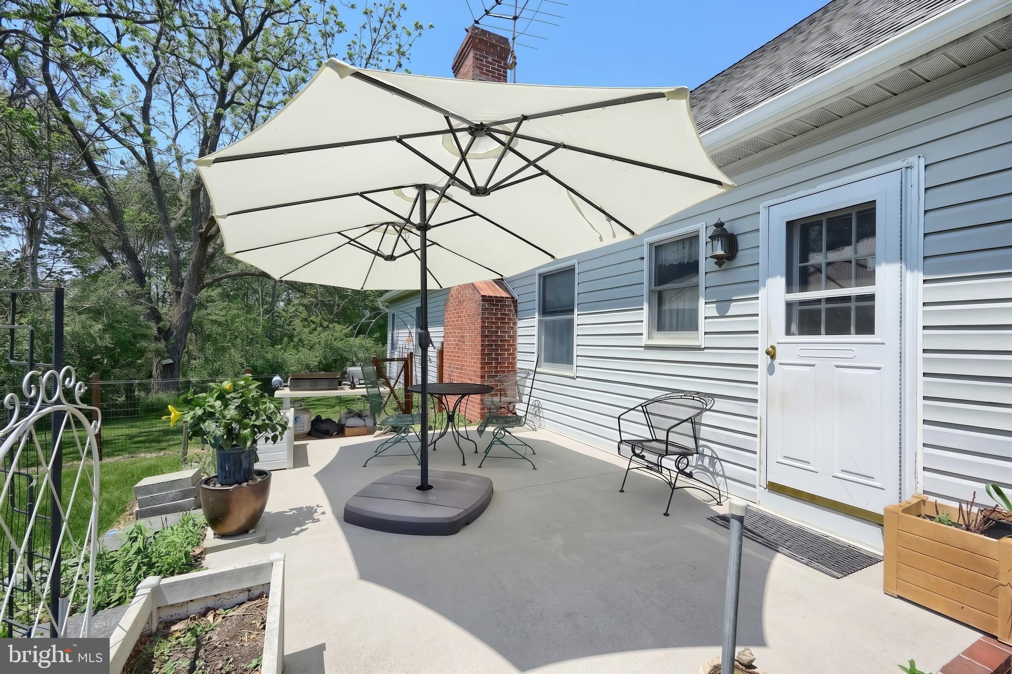 355 Sachs Road Gettysburg, PA 17325 - Photo 31 of 49 a view of a patio with couches table and chairs under an umbrella