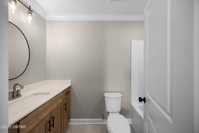 a bathroom with a granite countertop sink toilet and a mirror