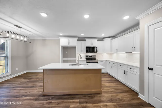 a large kitchen with kitchen island a sink a stove and refrigerator