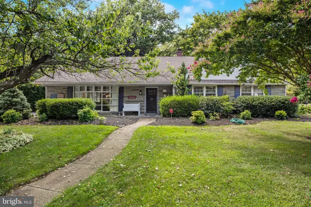 a front view of a house with a yard and potted plants