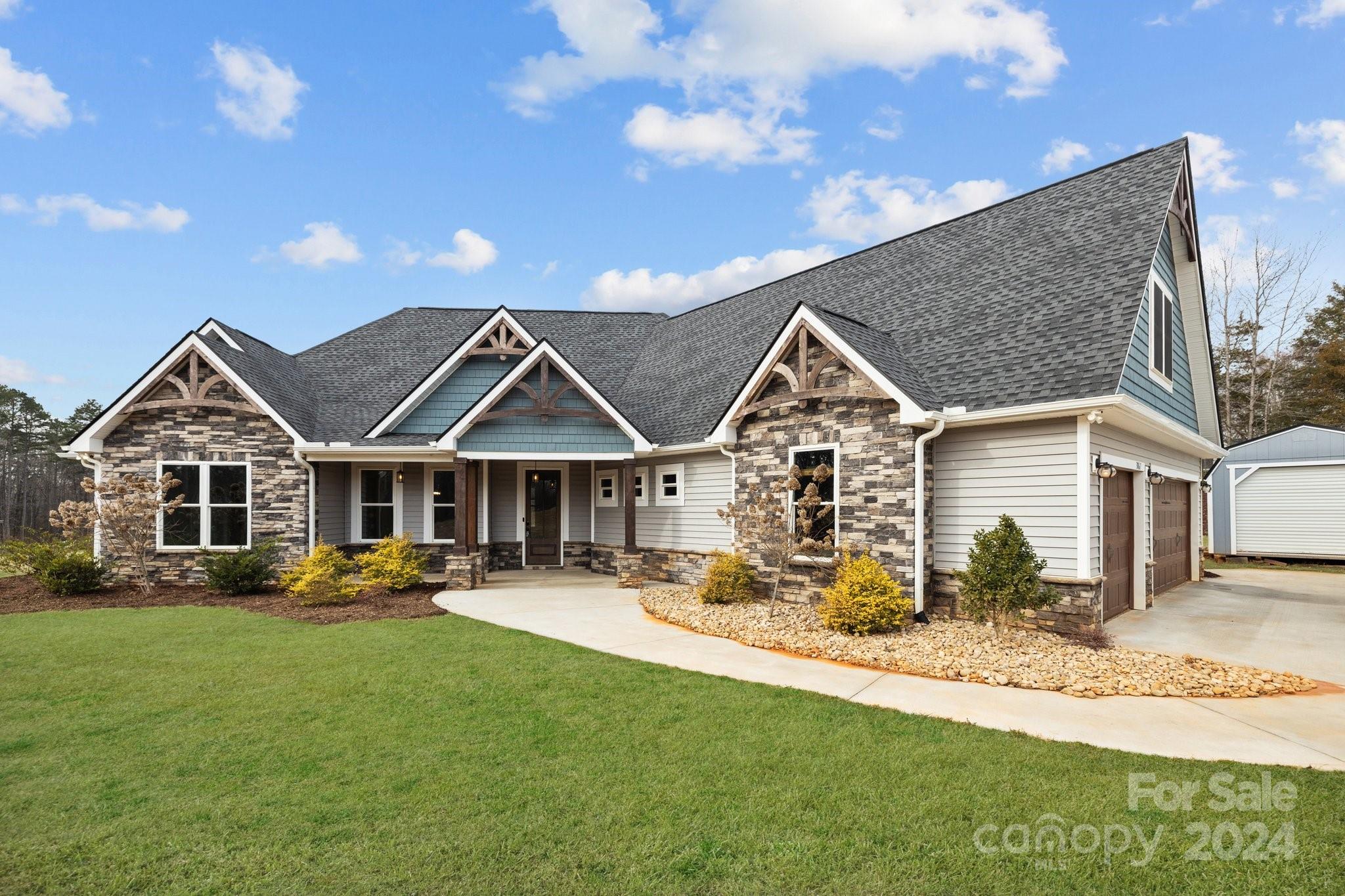 a view of a house with a big yard and large trees