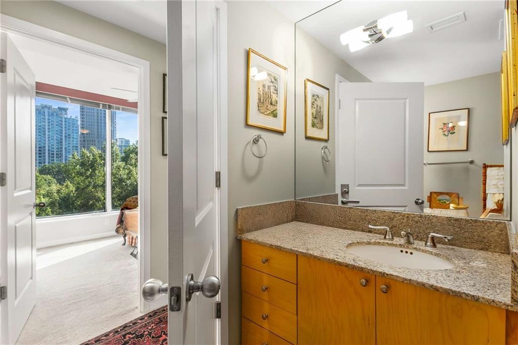 3338 Peachtree Road Northeast, Unit 407 Atlanta, GA 30326 - Photo 12 of 39 a bathroom with a granite countertop sink mirror and shower
