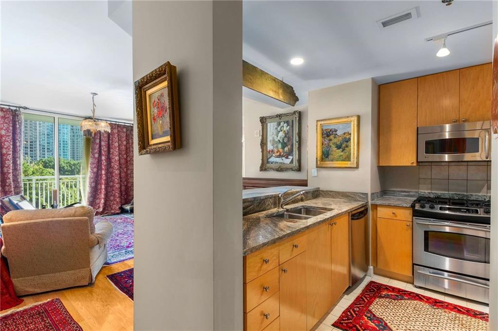 3338 Peachtree Road Northeast, Unit 407 Atlanta, GA 30326 - Photo 2 of 39 a kitchen that has a sink wooden floor and a window