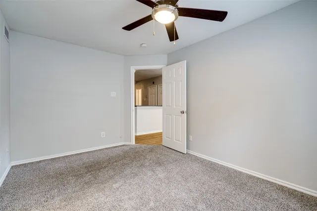 an empty room with closet and a chandelier fan