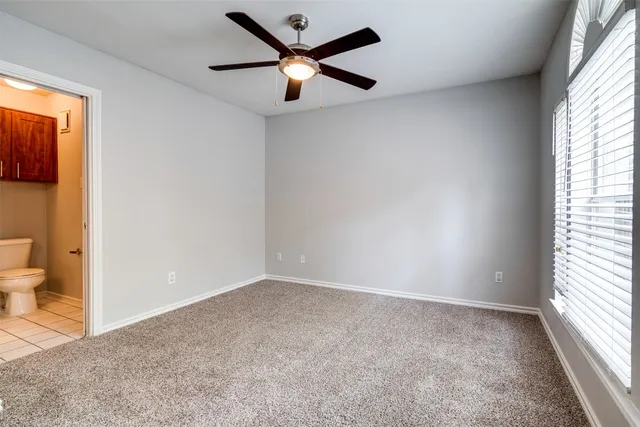 an empty room and a window with a fan