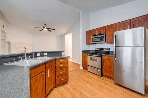 a kitchen with stainless steel appliances granite countertop a sink stove and refrigerator