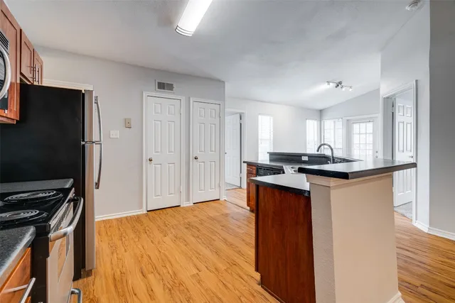 a kitchen with stainless steel appliances granite countertop a refrigerator and a stove top oven
