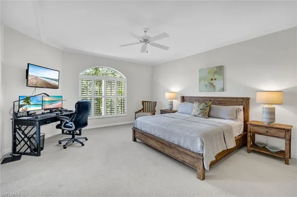 a spacious bedroom with a bed a table and a large window