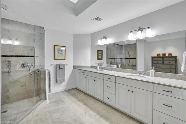 a spacious bathroom with a granite countertop sink mirror and shower