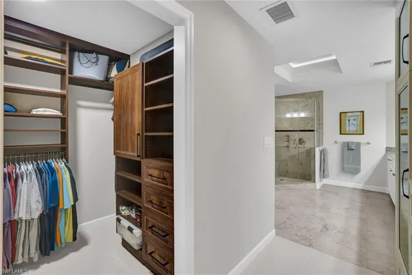a view of walk in closet with clothes and shoes