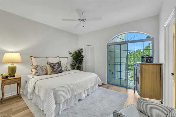 a bedroom with a bed a mirror and a window