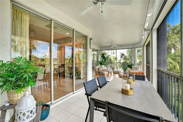 a dining room with furniture a chandelier and glass door
