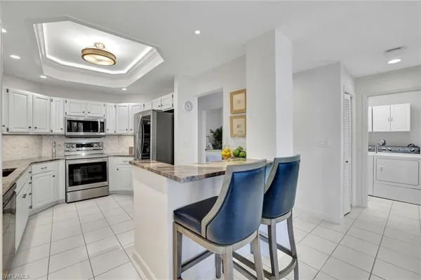 a kitchen with stainless steel appliances a stove a sink cabinets and a dining table