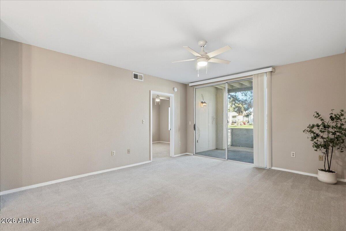 1825 West Ray Road, Unit 1106 Chandler, AZ 85224 - Photo 11 of 62 an empty room with a ceiling fan and a window
