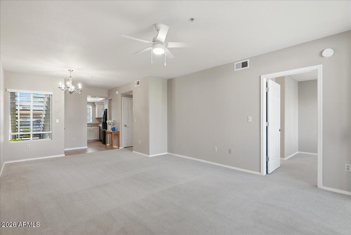 1825 West Ray Road, Unit 1106 Chandler, AZ 85224 - Photo 13 of 62 an empty room with chandelier fan and windows