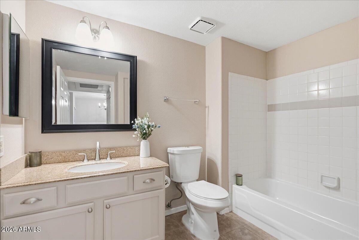 1825 West Ray Road, Unit 1106 Chandler, AZ 85224 - Photo 23 of 62 a bathroom with a toilet a sink a tub and a mirror