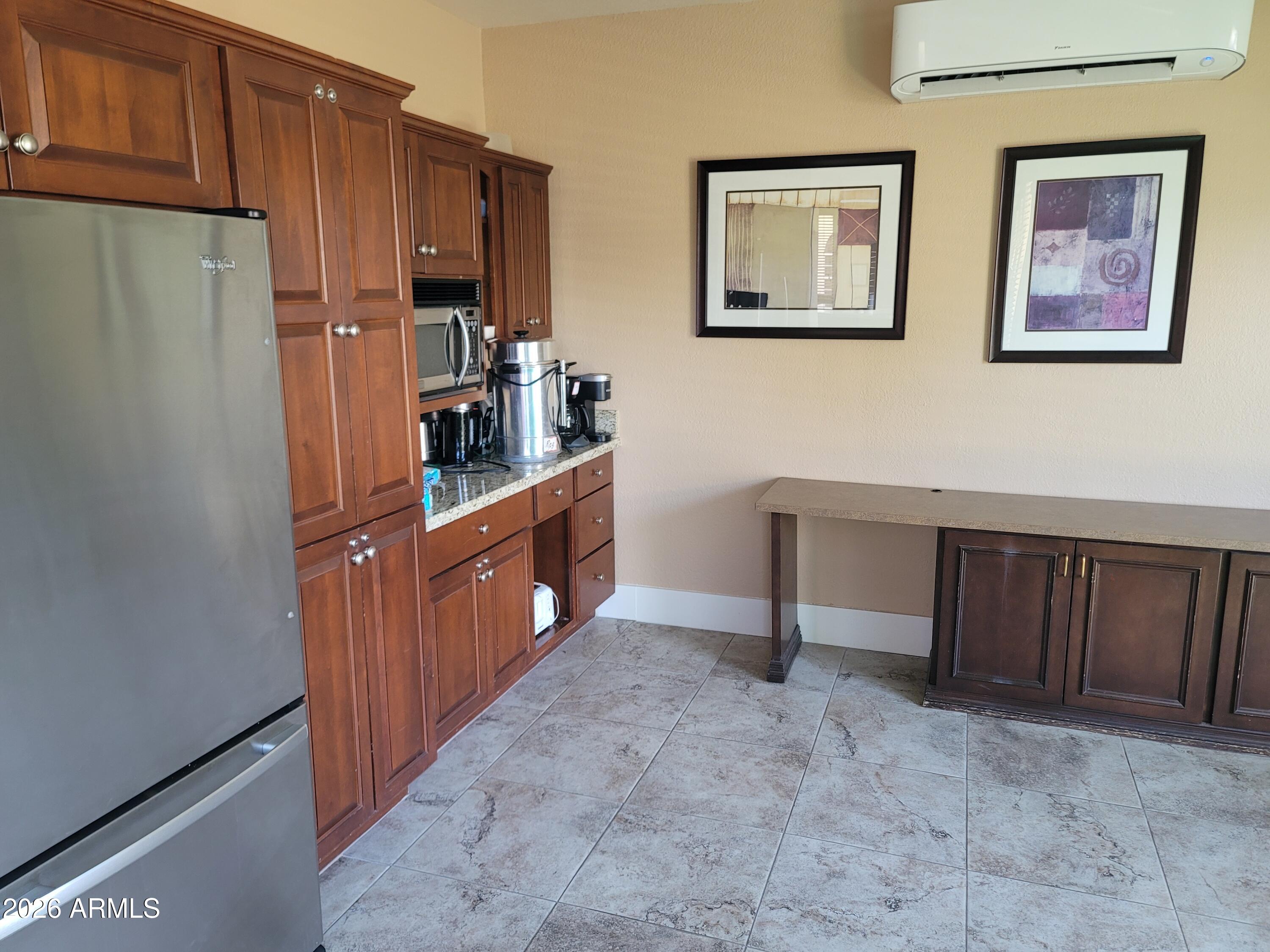 1825 West Ray Road, Unit 1106 Chandler, AZ 85224 - Photo 51 of 62 a kitchen with stainless steel appliances a refrigerator and wooden cabinets