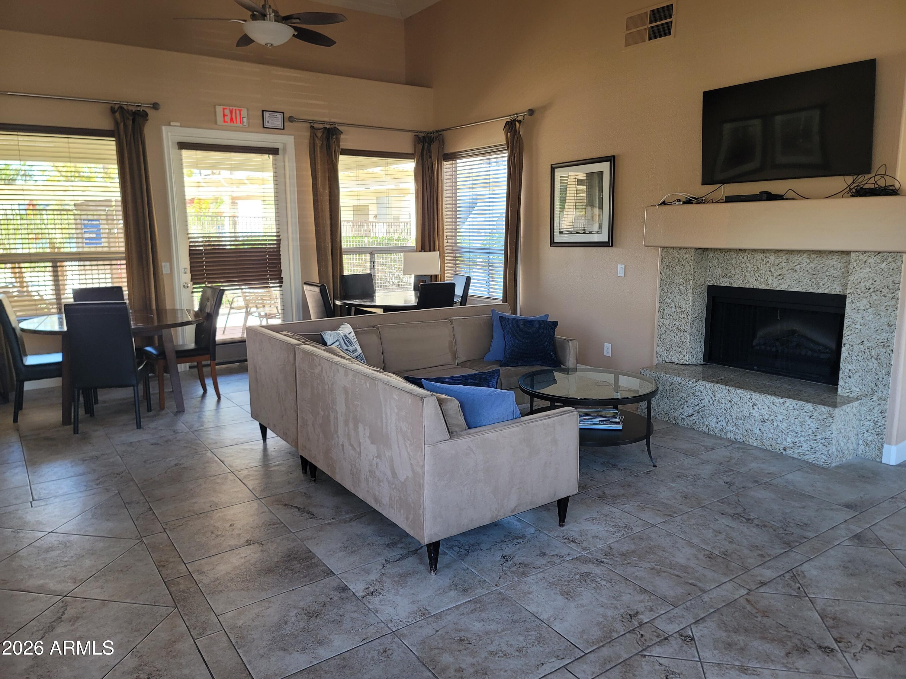 1825 West Ray Road, Unit 1106 Chandler, AZ 85224 - Photo 53 of 62 a living room with furniture a flat screen tv and a fireplace