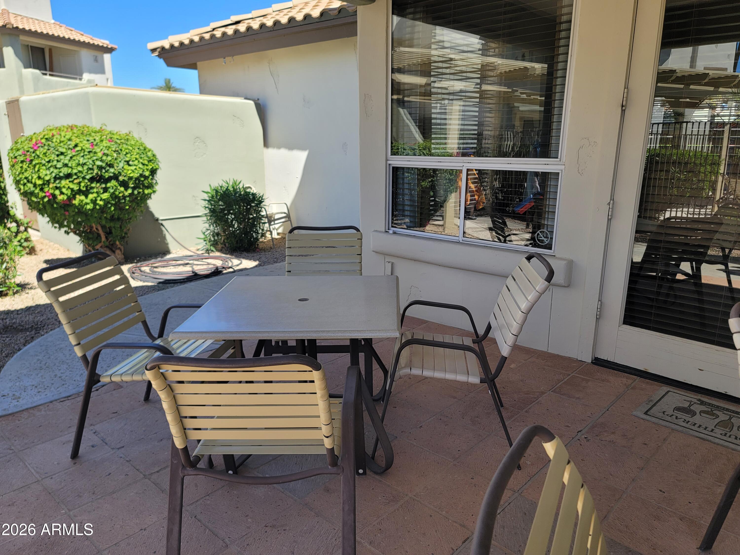 1825 West Ray Road, Unit 1106 Chandler, AZ 85224 - Photo 59 of 62 a view of a patio with table and chairs and potted plants