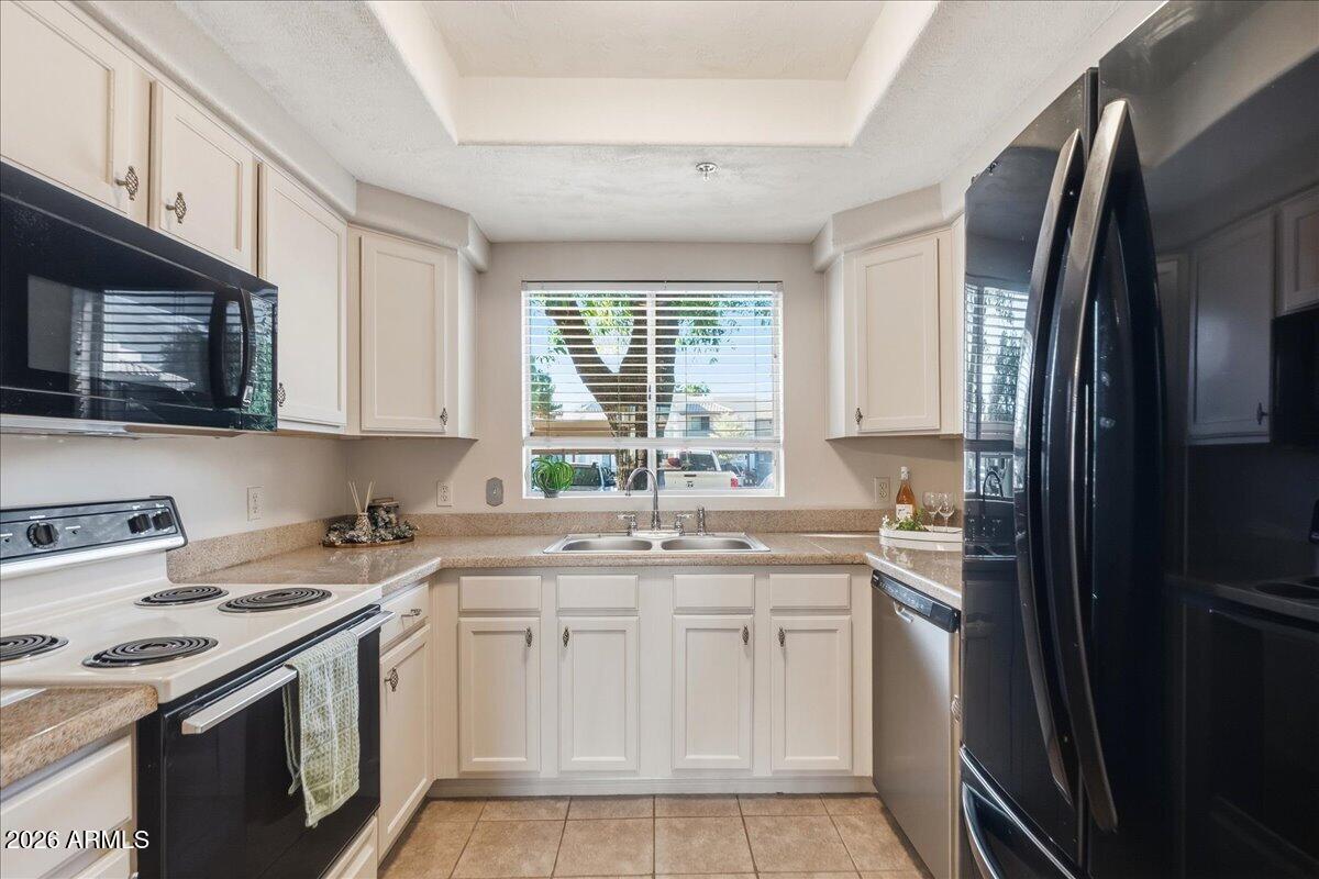 1825 West Ray Road, Unit 1106 Chandler, AZ 85224 - Photo 5 of 62 a kitchen with stainless steel appliances granite countertop a sink stove refrigerator and microwave