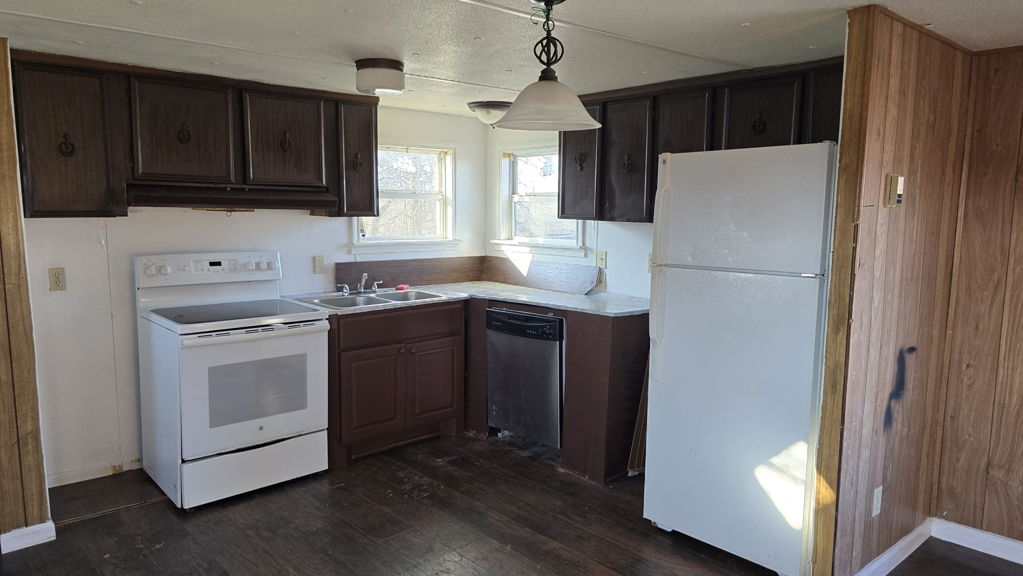 18509 Blake Manor Road Manor, TX 78653 - Photo 5 of 17 a kitchen with a sink a refrigerator a microwave and cabinets