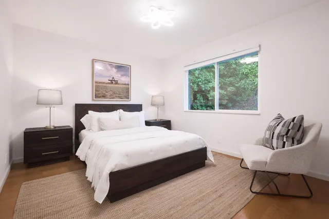 a bedroom with a bed and wooden floor