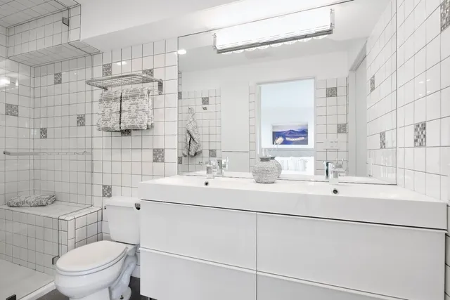 a bathroom with a sink toilet vanity and shower