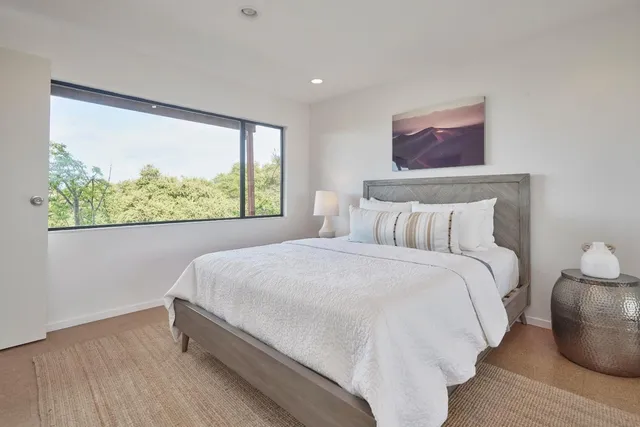 a bedroom with a bed and a painting on the wall