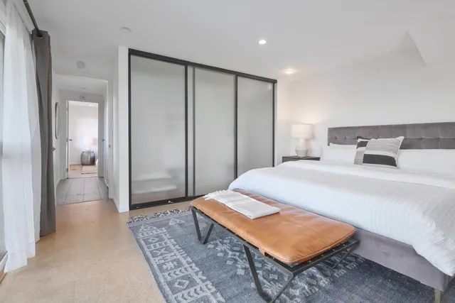 a spacious bedroom with a bed and glass door