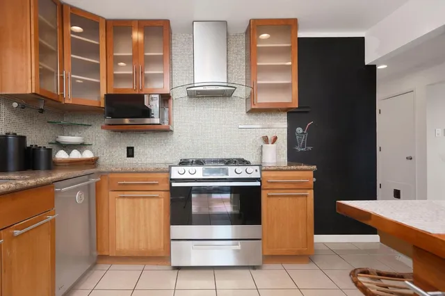 a kitchen with stainless steel appliances granite countertop a stove a sink and a microwave