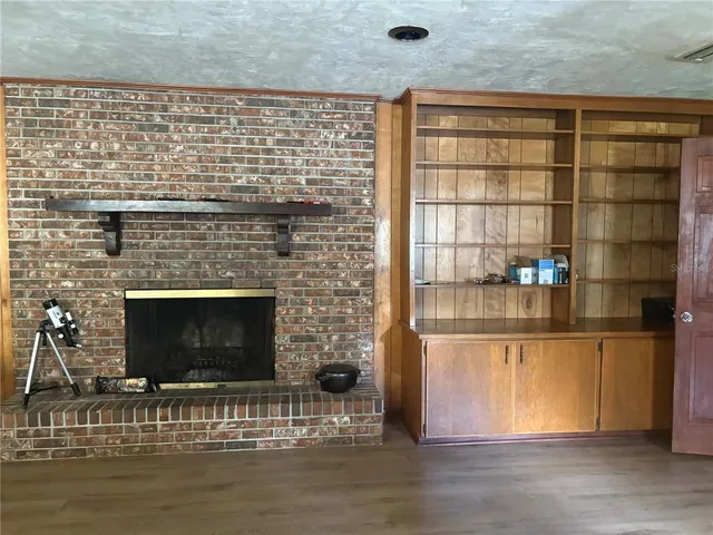 a view of an empty room with a fireplace and window