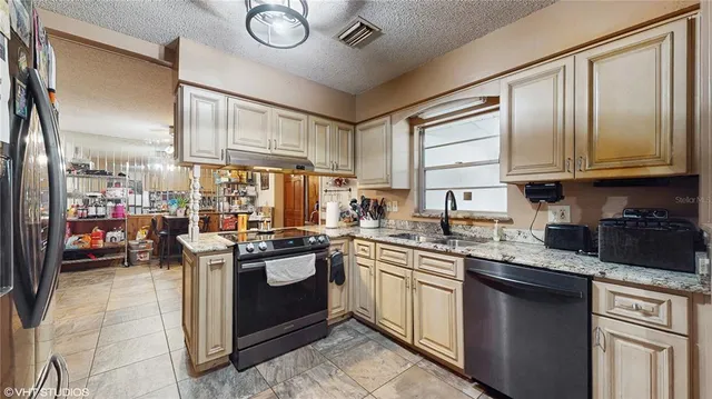 a kitchen with stainless steel appliances granite countertop a stove sink and cabinets
