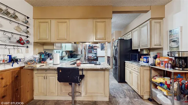 a kitchen with stainless steel appliances kitchen island granite countertop a refrigerator a stove a sink dishwasher and white cabinets with wooden floor