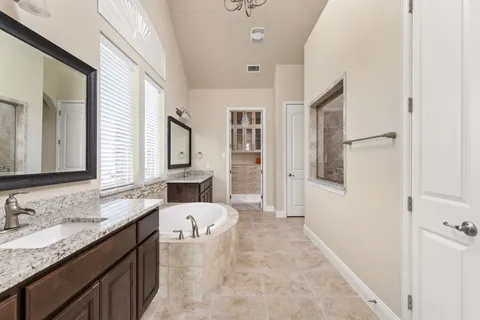 a bathroom with a tub sink and mirror