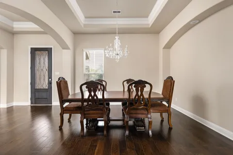 a view of a dining room with furniture a chandelier and wooden floor