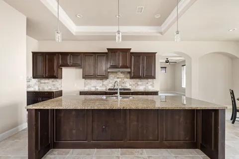 a kitchen with granite countertop a sink cabinets and stainless steel appliances