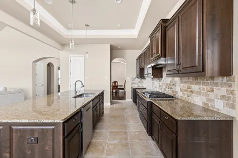 a kitchen with stainless steel appliances granite countertop a sink stove and cabinets