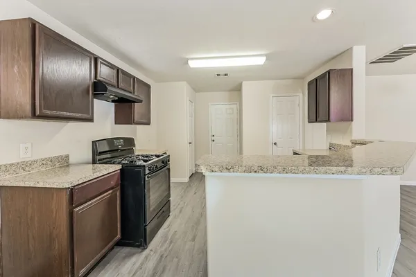 a kitchen with granite countertop stainless steel appliances and wooden cabinets