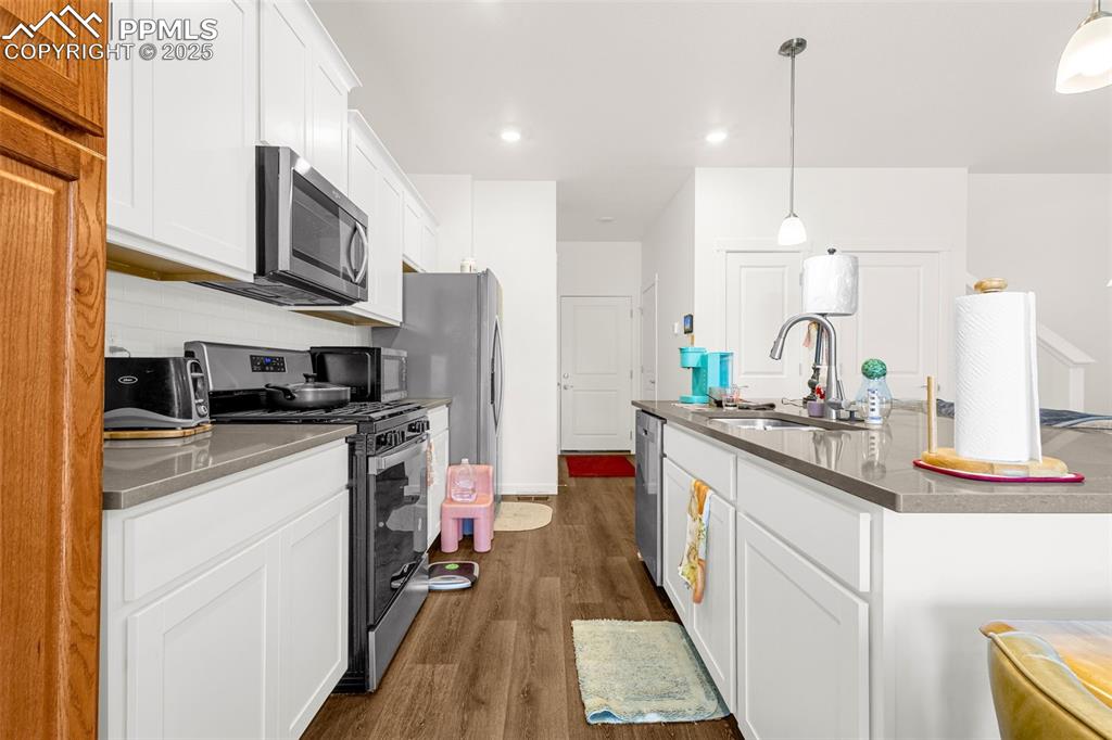 2325 Coyote Mint Drive Monument, CO 80132 - Photo 8 of 26 a kitchen with stainless steel appliances granite countertop a sink a stove and a refrigerator