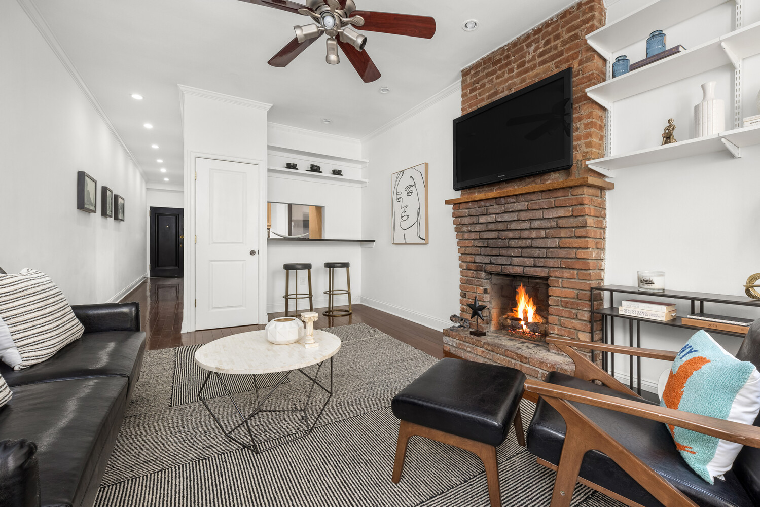 433 West 24th Street, Unit 3D Manhattan, NY 10011 - Photo 5 of 7 a living room with furniture a flat screen tv and kitchen view