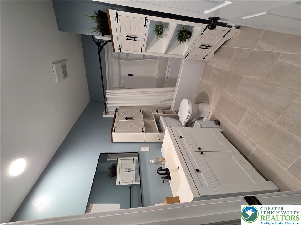 89 Short Ridge Road Albrightsville, PA 18210 - Photo 36 of 71 A modern vanity with a large mirror pairs with large-format floor tiles.
