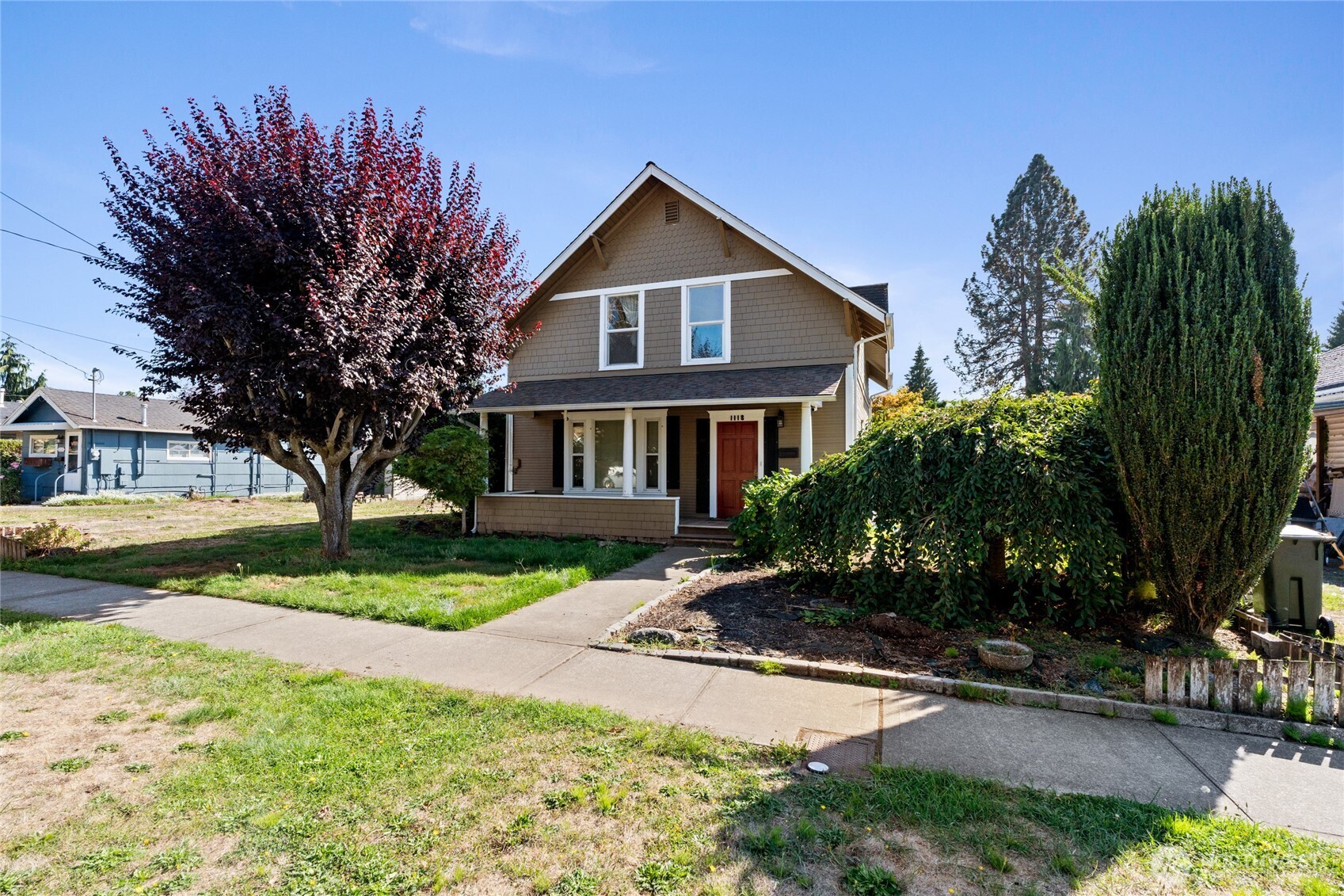 a front view of a house with a yard and trees