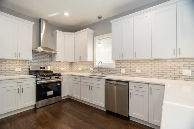 a kitchen with granite countertop white cabinets and appliances