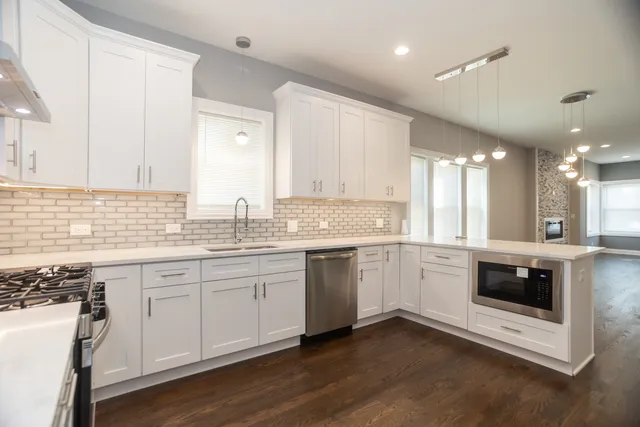 a kitchen with granite countertop white cabinets and white appliances