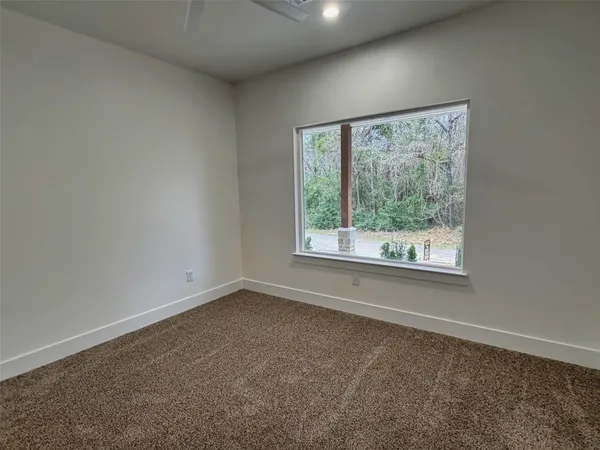 a bedroom with a bed a couch and potted plant on the dresser
